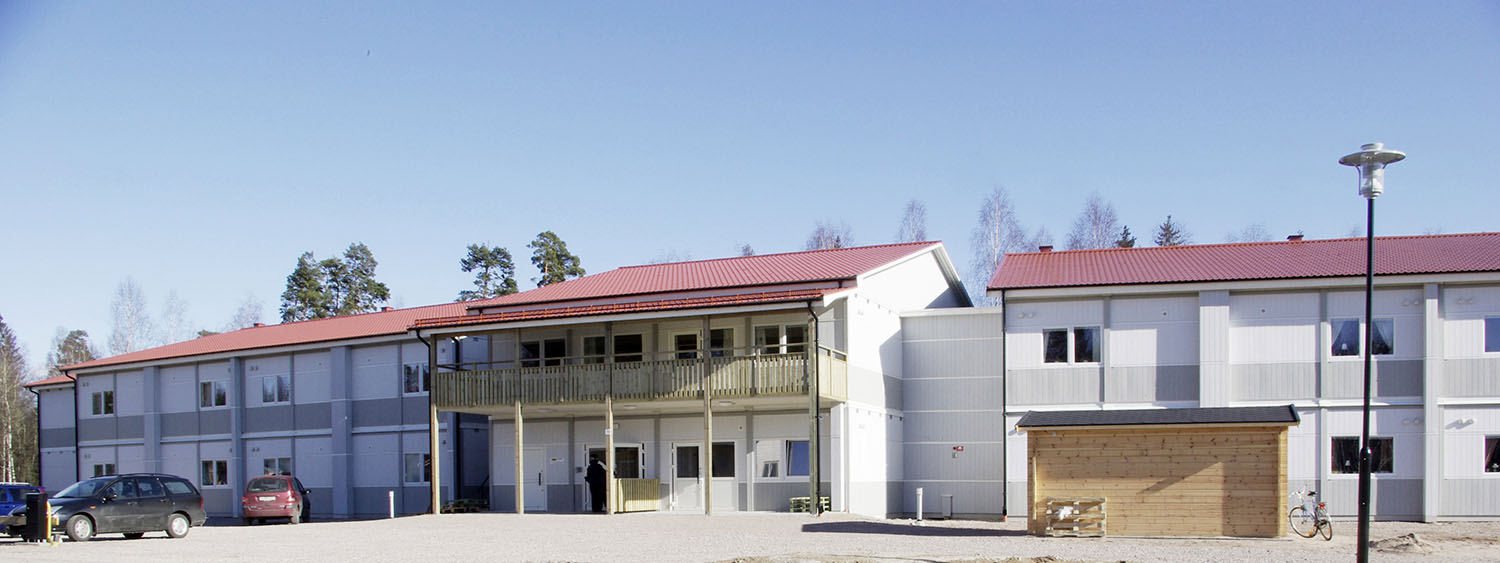 Vidingehem Bo i Växjö – boendemoduler från Expandia med ljusa fasader och rött sadeltak, placerade i en öppen miljö med grusad gård.