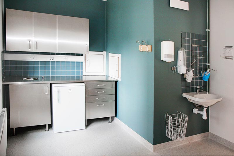 Undersökningsrum i modul från Expandia vid Östra sjukhuset i Göteborg, utrustat med förvaring, arbetsbänk, kylskåp, handfat och medicinsk väggutrustning för vårdverksamhet.