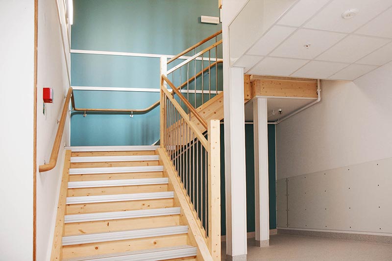 Trapphus i modul från Expandia vid Östra sjukhuset, med trätrappa, räcken och ljusa ytskikt anpassade för vårdmiljö.